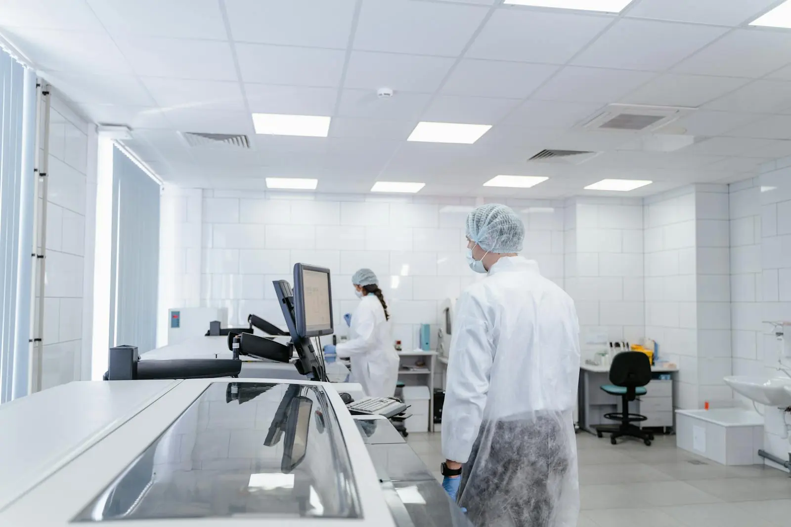 Healthcare and life-sciences team working with controlled laboratory equipment and digital review systems